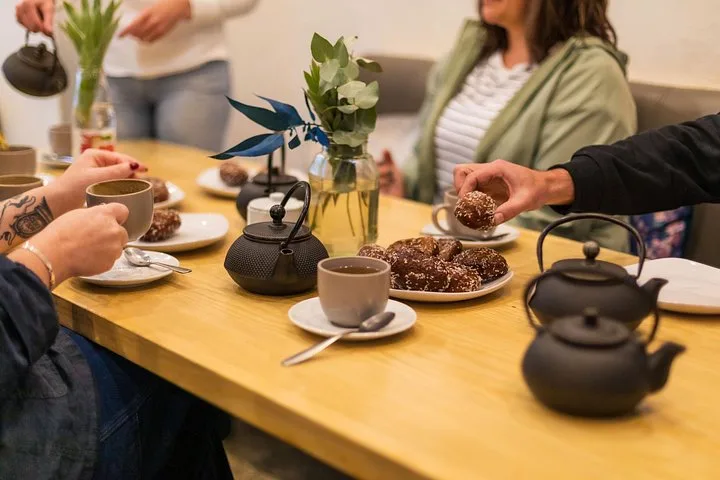 Tea in cast-iron pots with small cakes on a shared table